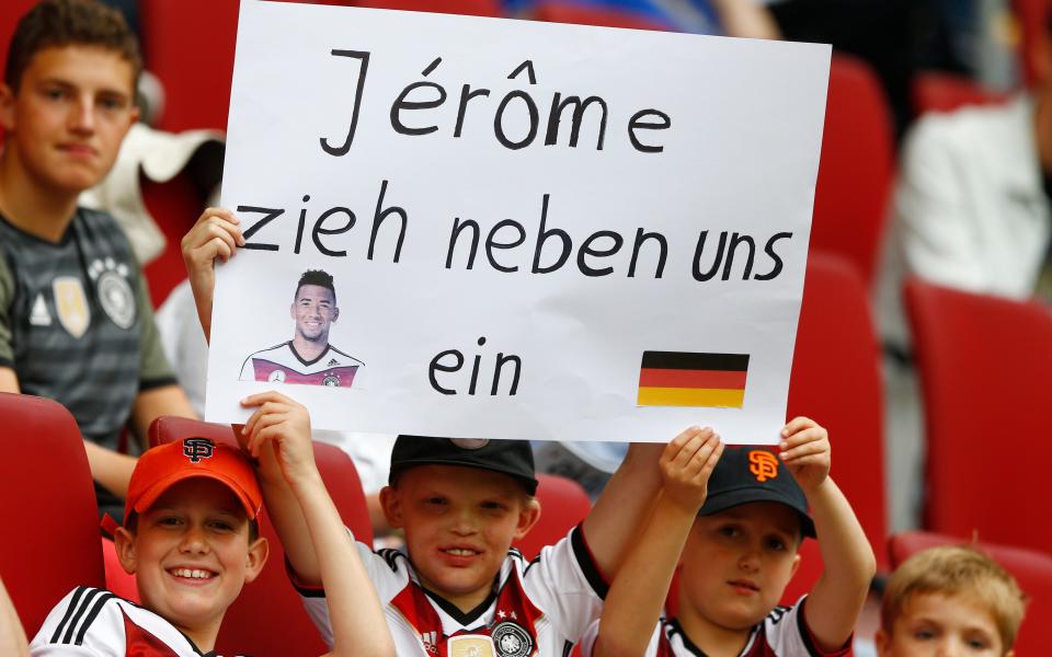 A boy holds a poster "Jerome move in as our neighbour"  - Credit: AP