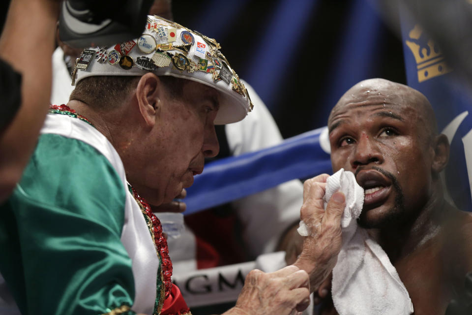 Floyd Mayweather Jr., right, is tended to in his corner during his WBC-WBA welterweight title boxing fight against Marcos Maidana Saturday, May 3, 2014, in Las Vegas. (AP Photo/Isaac Brekken)