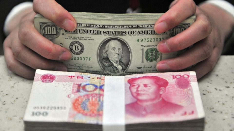 Yuan und Dollar in einer Bankfiliale: Amerikas Tech-Unternehmen raten im Handelsstreit mit China dringend von Strafzöllen ab. Foto: Mark/EPA