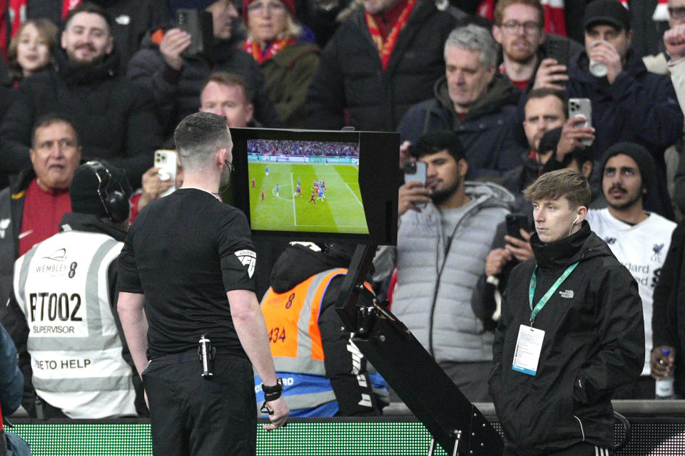 Referee Chris Kavanagh pauses the match and asks for the VAR to check on a possible goal during the English League Cup final soccer match between Chelsea and Liverpool at Wembley Stadium in London, Sunday, Feb. 25, 2024. (AP Photo/Dave Shopland)