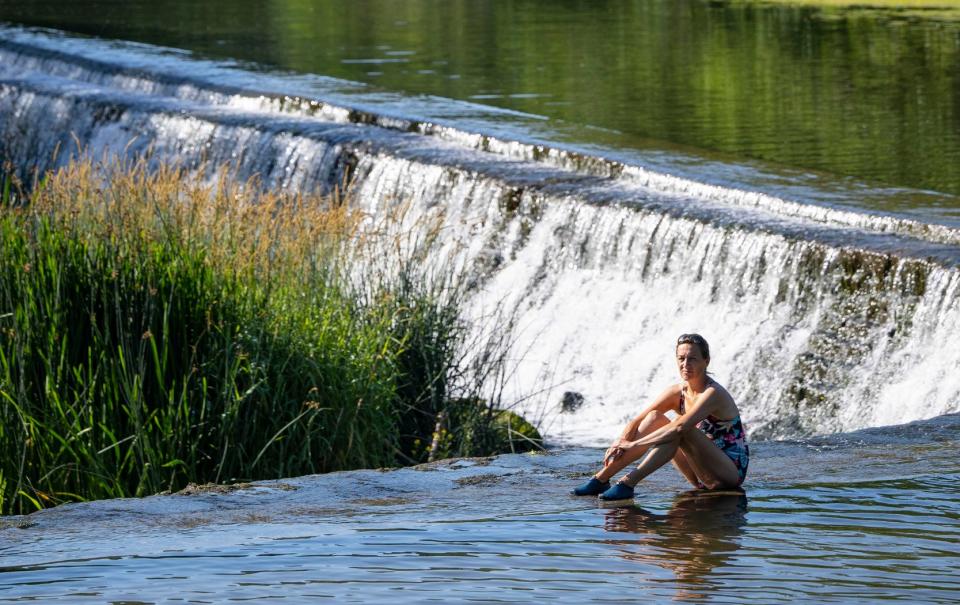 People cool off in the river Avon at Warleigh Weir near Bath in Somerset - ANDREW LLOYD