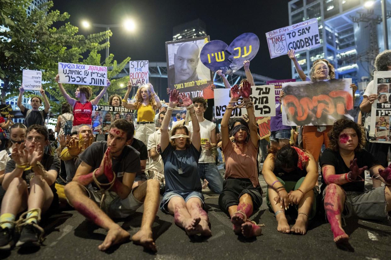 Blindfolded and bounded protesters take part in a protest against Israeli Prime Minister Benjamin Netanyahu's government and call for the release of hostages held in the Gaza Strip by the Hamas militant group in Tel Aviv, Israel, Tuesday, Sept. 10, 2024. (AP Photo/Ohad Zwigenberg)