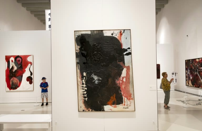 Visitors look at paintings on July 11, 2018 at the Soulages museum in Rodez, as part of an exhibition on the Gutai artistic movement