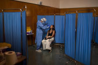 A Spanish NGO Open Arms volunteer takes a swab to test a woman for COVID-19, at Vilafranca del Penedes in the Barcelona province, Spain, Tuesday, Aug. 11, 2020. Spain is facing another surge in coronavirus infections not even two months after beating back the first wave. (AP Photo/Emilio Morenatti)