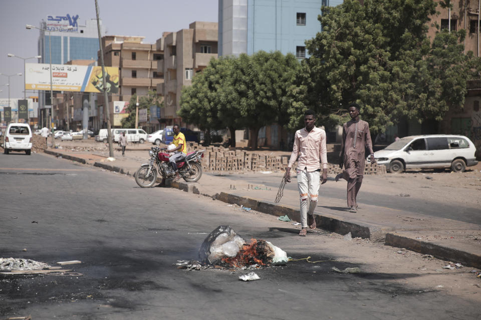 People walk on a street in Khartoum, Sudan, two days after a military coup, Wednesday, Oct. 27, 2021. The coup threatens to halt Sudan's fitful transition to democracy, which began after the 2019 ouster of long-time ruler Omar al-Bashir and his Islamist government in a popular uprising. It came after weeks of mounting tensions between military and civilian leaders over the course and pace of that process. (AP Photo/Marwan Ali)