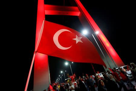 A Turkish national flag waves as pro-government demonstrators march over the Bosphorus Bridge, from the Asian to the European side of Istanbul, Turkey, July 21, 2016. REUTERS/Murad Sezer