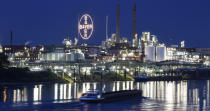 FILE - A ship passes the main chemical plant of German Bayer AG on Thursday, Aug. 9, 2019 in Leverkusen, Germany. A low-rise city of 167,000 that grew up around the factories of the pharmaceuticals giant Bayer, Leverkusen has little to draw tourists besides its internationally famed soccer club. The team finished an entire German Bundesliga season unbeaten Saturday and is now targeting trophies in the Europa League and German Cup. (AP Photo/Martin Meissner, File)
