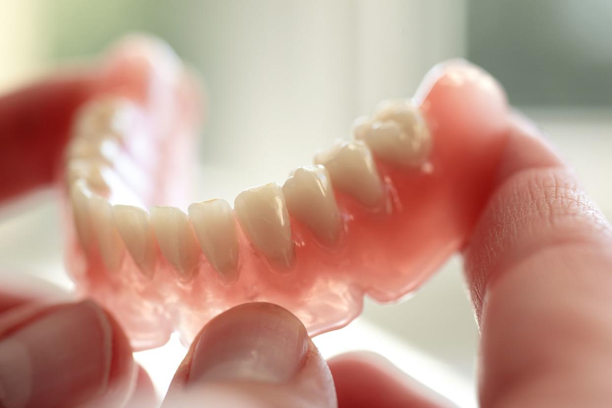 dental technician holding a denture