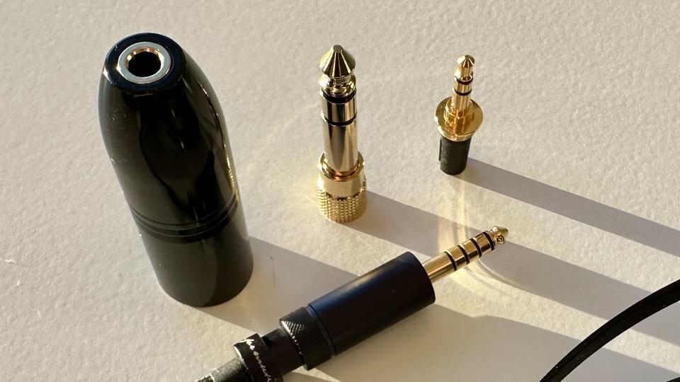 The Fiio FT5's 4.4mm, 6.3mm and 4-pin XLR adapters, on a white background