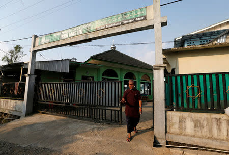 A security guard for the Ibnu Mas'ud Islamic boarding school blocks the gate of the compound in Bogor, Indonesia, July 19, 2017. REUTERS/Beawiharta/Files