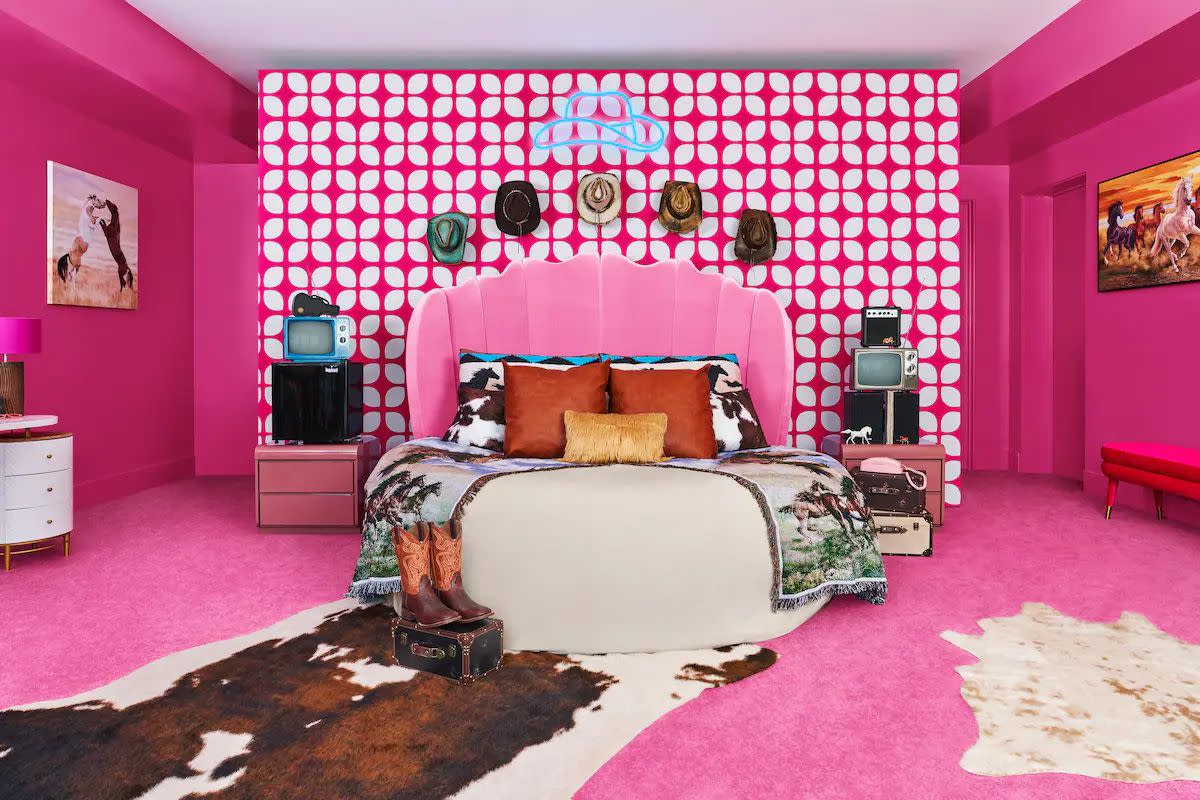 A look at the real-life Barbie Dreamhouse bedroom bedecked in pink and featuring some western-themed touches like cowboy hats, a cow-skin rung, and more.