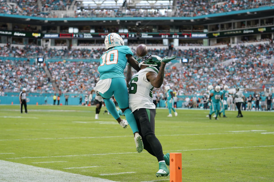 New York Jets linebacker Quincy Williams (56) defends Miami Dolphins wide receiver Tyreek Hill (10) as he can't hold onto a pass during the second half of an NFL football game, Sunday, Jan. 8, 2023, in Miami Gardens, Fla. (AP Photo/Lynne Sladky)