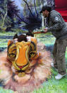 An artist paints a 3D body painting depicting a tiger's face on the backs of three models in Fuzhou, Fujian province January 3, 2012. The models were wearing white shirts for the painting as a call for increased awareness of protecting endangered animals. REUTERS/China Daily