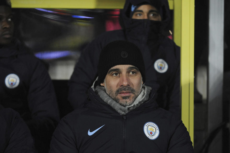 Manchester City manager Pep Guardiola awaits the start of the English League Cup semifinal soccer match between Burton Albion and Manchester City at Pirelli Stadium in Burton on Trent, England, Wednesday, Jan. 23, 2019. (AP Photo/Rui Vieira)