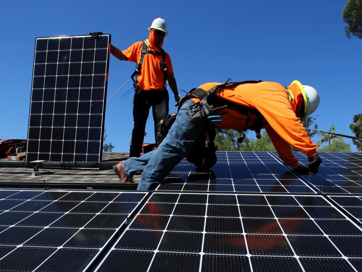 Installers place solar panels on the roof of a residential home in San Diego, California, in this October 2016 photo. Most of Nova Scotia's 4,100 net metering customers are residential customers with solar power.  (Mike Blake/Reuters - image credit)