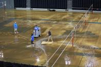 Workers try to clear water from the floor of Pauley Pavillion on the UCLA campus from a broken thirty inch water main, which gushed water onto Sunset Boulevard in the Westwood section of Los Angeles July 29, 2014. The geyser from the 100-year old water main flooded parts of the campus and stranded motorists on surrounding streets. REUTERS/Jonathan Alcorn