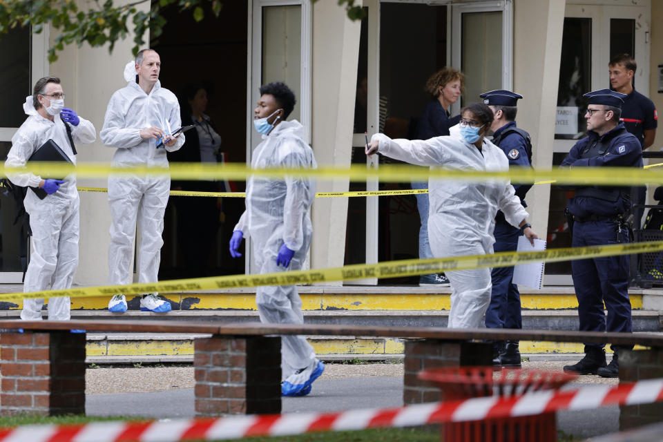 French police officers from the forensic service stand in front of the Gambetta high school in Arras, northeastern France, after a man armed with a knife killed a teacher and wounded another teacher and a security guard, an attack being investigated as potential terrorism, Friday Oct. 13, 2023. (Ludovic Marin, Pool via AP)