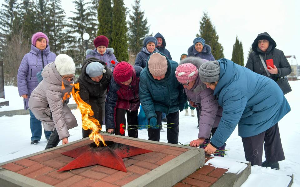 Women lay flowers in memory of those who were killed in the plane on Wednesday, at the memorial to soldiers who died in the Great Patriotic War "Enternal Flame" in Belgorod, Russia