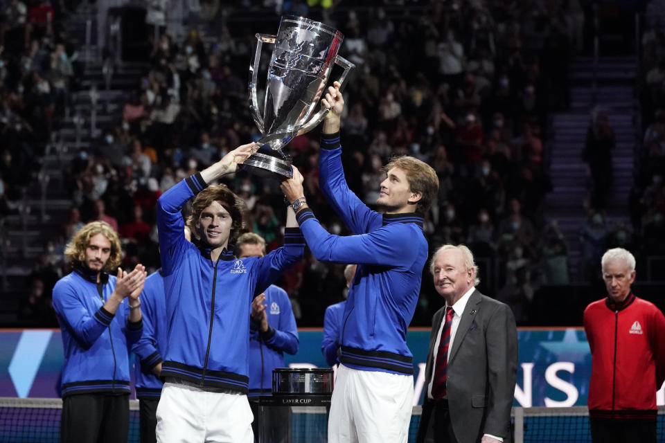 Team Europe's Andrey Rublev, left, and Alexander Zverev hold the Laver Cup aloft after they defeated Team World for tennis' Laver Cup, Sunday, Sept. 26, 2021, in Boston. Looking on, at right, is tennis great Rod Laver, and at far right, Team World captain John McEnroe. (AP Photo/Elise Amendola)