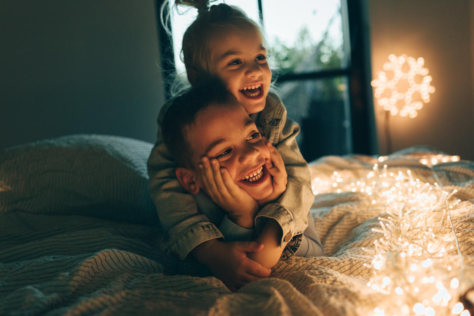 Cute boy and a girl lying on the bed in Christmas day