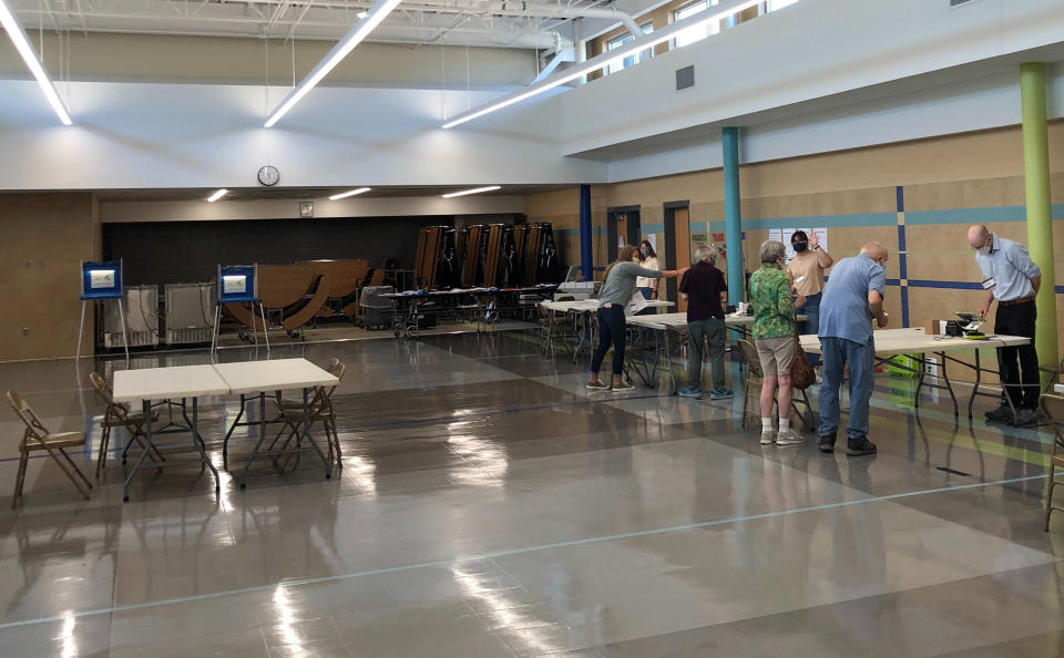 Minnesota residents vote in a statewide primary election, Tuesday, Aug. 11, 2020, in Minneapolis, that includes congressional and legislative elections. Top races including Rep. Ilhan Omar's bid for a second term coming up against well-funded challenger Antone Melton-Meaux. With absentee voting heavy, in-person turnout was light, as at this southwest Minneapolis precinct. (AP Photo/Doug Glass)