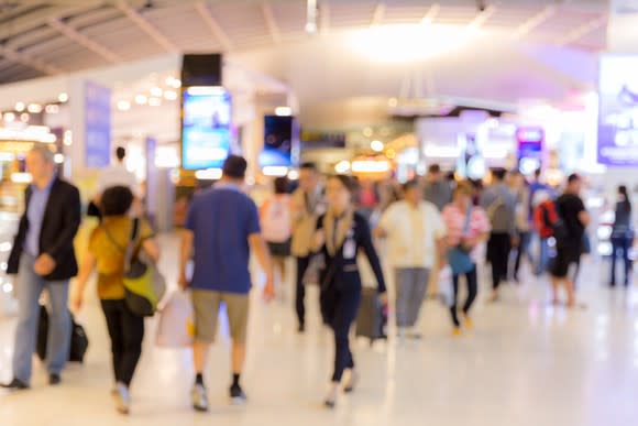Passengers walking through an airport boarding area; blurred photographic effect.