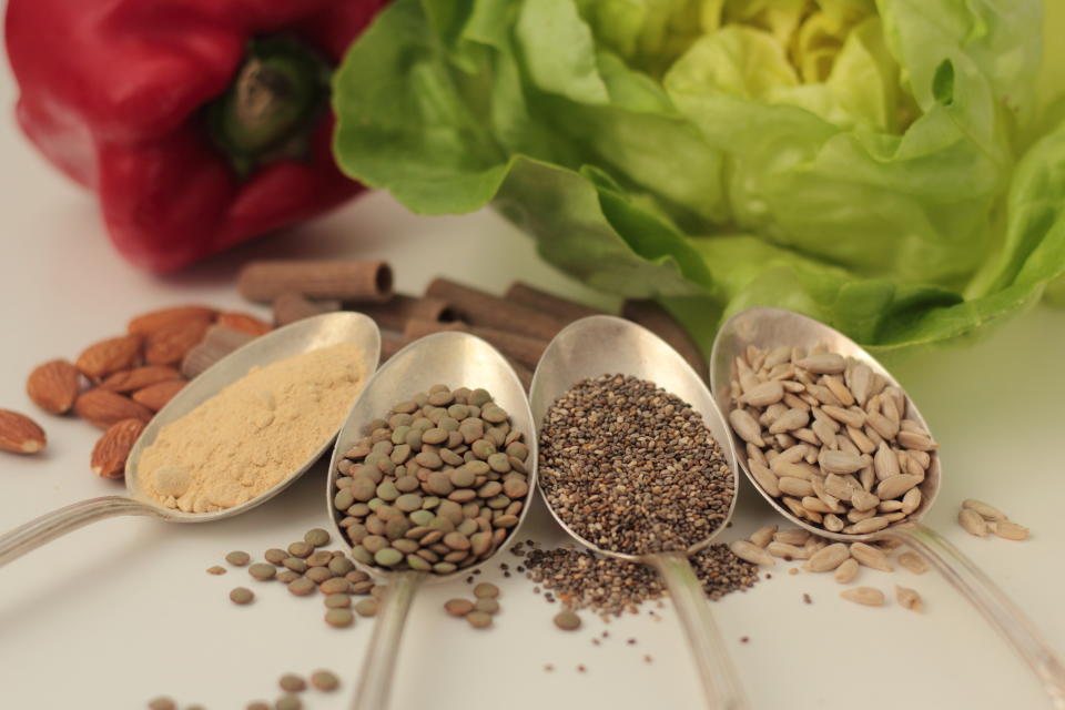 Sample foods from low-GI PCOS (Polycystic Ovary Syndrome) diet. Lentils, chia seeds, sunflower seeds, maca powder, almonds, buckwheat pasta, bell pepper and lettuce.