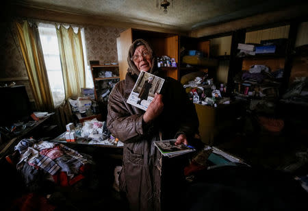 A local resident shows a family photo in her home which was damaged during fighting between the Ukrainian army and pro-Russian separatists in the government-held industrial town of Avdiyivka, Ukraine, February 6, 2017. REUTERS/Gleb Garanich