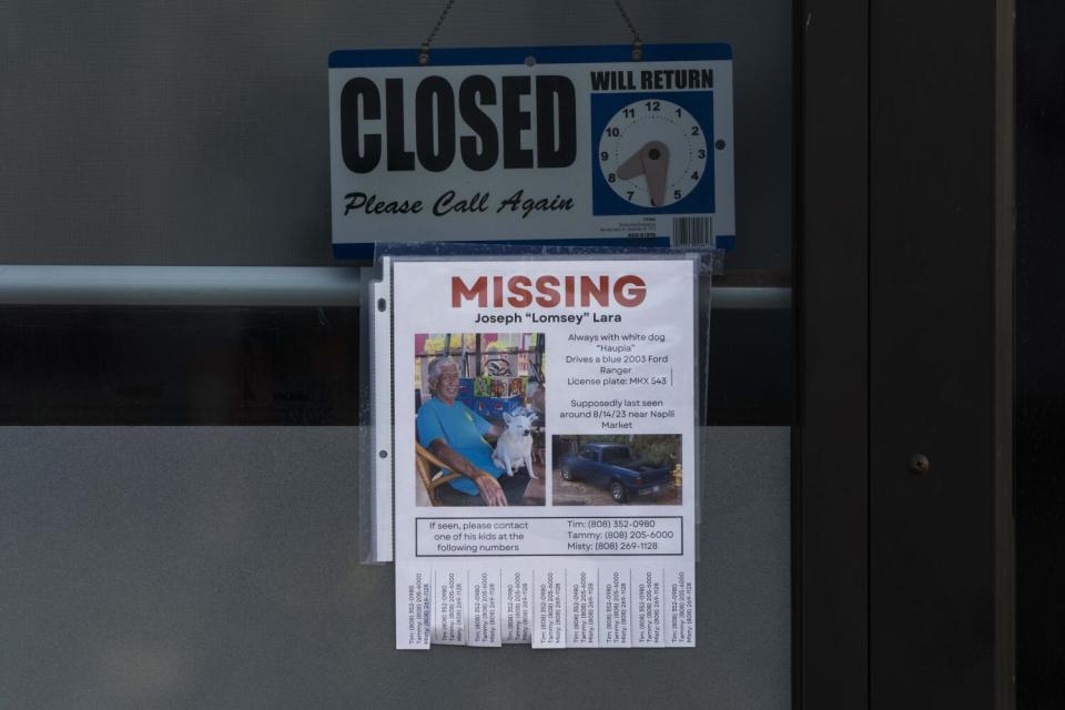 A missing person flier for Joseph "Lomsey" Lara is posted on the door of a business.