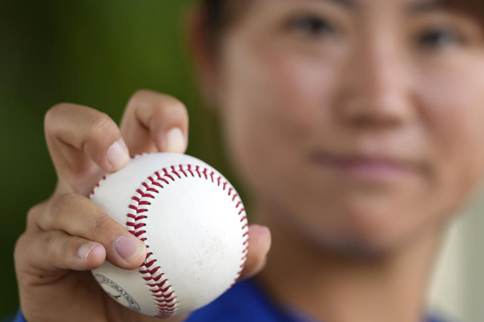 Eri Yoshida of a Japanese women's team, Agekke, shows her knuckleball grip during an interview in Oyama, Tochigi prefecture, north of Tokyo, Tuesday, May 30, 2023. The 31-year-old Japanese woman is a knuckleball pitcher with a sidearm delivery that she hopes might carry her to the big leagues in the United States or Japan. (AP Photo/Shuji Kajiyama)