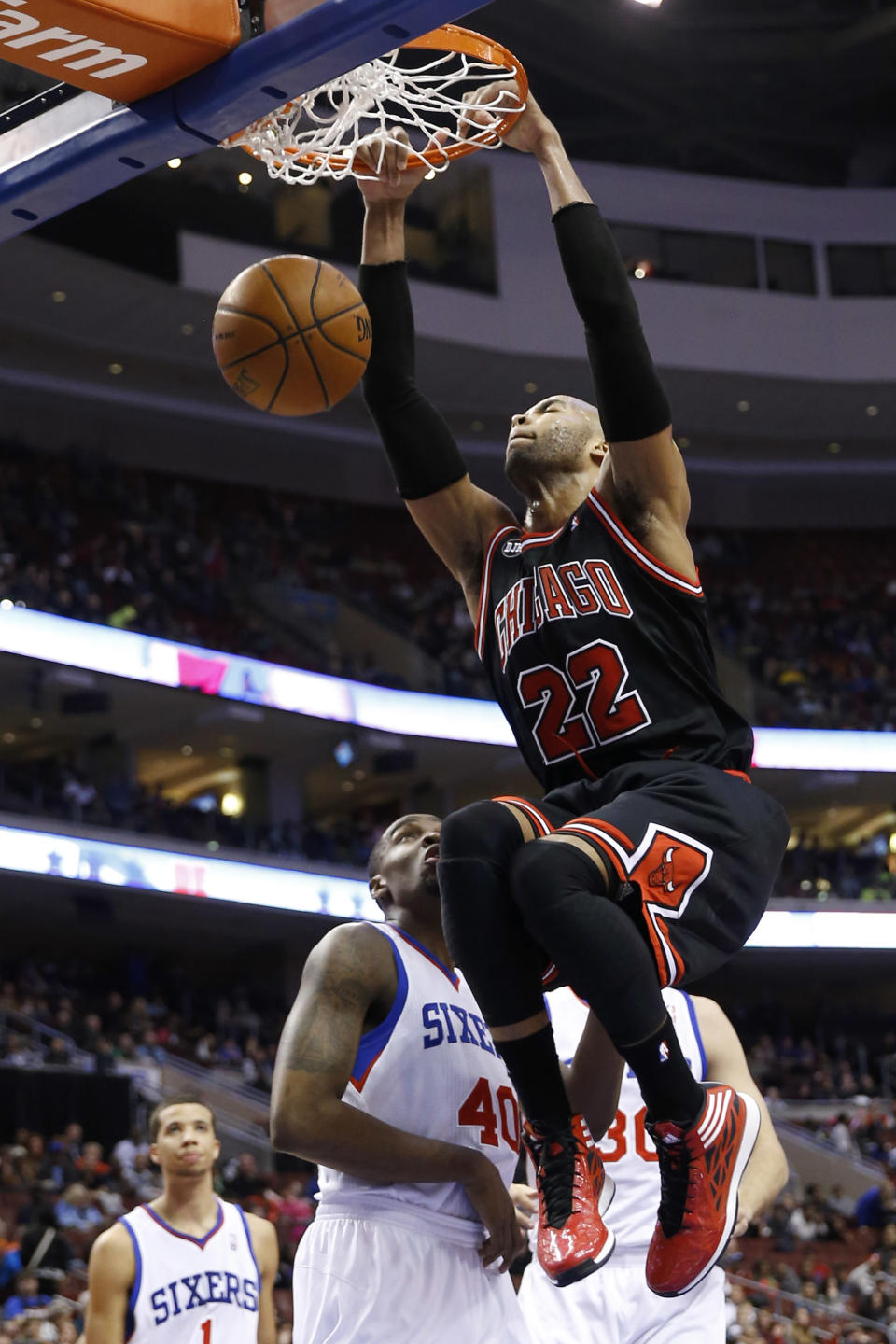 Chicago Bulls' Taj Gibson (22) dunks the ball past Philadelphia 76ers' Jarvis Varnado (40) during the first half of an NBA basketball game, Wednesday, March 19, 2014, in Philadelphia. (AP Photo/Matt Slocum)