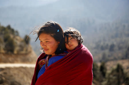 A woman carries her daughter near Punakha, Bhutan, December 14, 2017. REUTERS/Cathal McNaughton