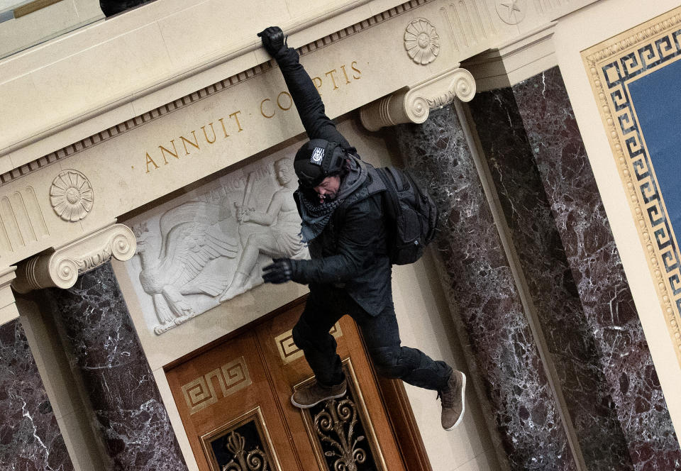 WASHINGTON, DC - JANUARY 06: A protester supporting U.S. President Donald Trump  jumps from the public gallery to the floor of the Senate chamber at the U.S. Capitol Building on January 06, 2021 in Washington, DC. Congress held a joint session today to ratify President-elect Joe Biden's 306-232 Electoral College win over President Donald Trump. A group of Republican senators said they would reject the Electoral College votes of several states unless Congress appointed a commission to audit the election results (Photo by Win McNamee/Getty Images)