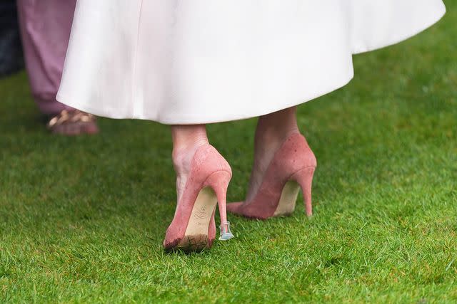<p>Yui Mok/POOL/AFP/Getty</p> Zara Tindall wears rain accessories on her heels at a Buckingham Palace garden party on May 21, 2024