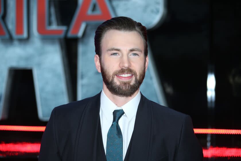 A bearded man in a suit smiles