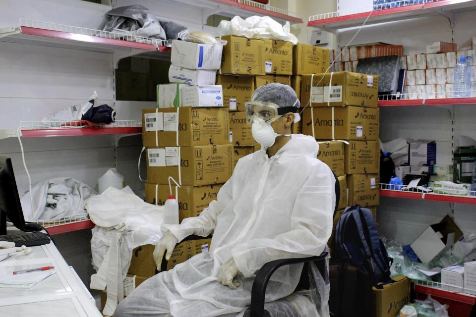 In this May 20, 2020 photo, a medical worker wearing protective gear waits at the entrance of a hospital with patients suspected of having the coronavirus in Aden, Yemen. The United Nations on Tuesday, June 2, 2020 urged countries to raise at least $2.4 billion for Yemen, where more than five years of war have pushed the country's health care system to a state of collapse. Reports indicate that in Aden, mortality rates from Covid-19 are among the highest in the world. (AP Photo/Wail al-Qubaty)