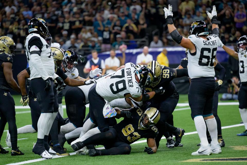Jaguars guard Brandon Scherff (68) celebrates Travis Etienne's first touchdown of the game on Thursday at New Orleans. Center Luke Fornter (79) is obscuring Etienne as he dives over the goal line.