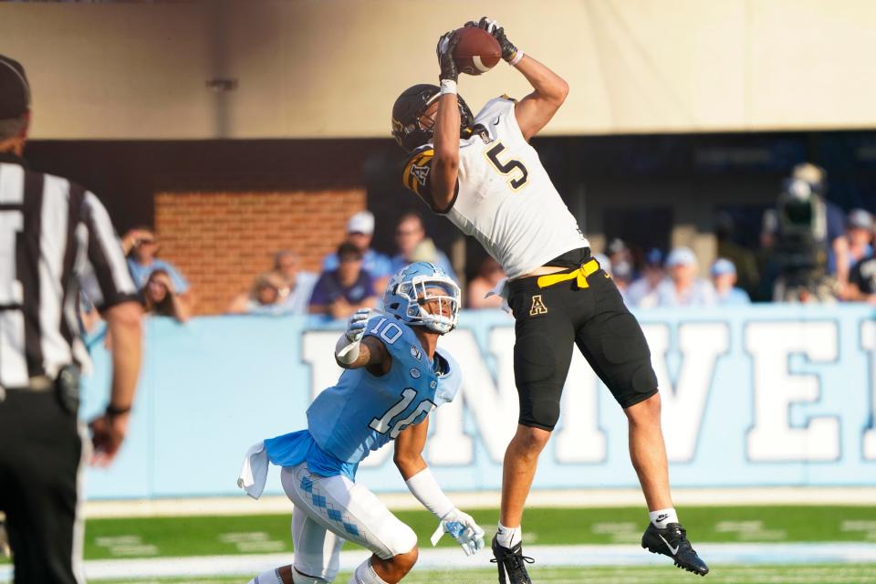 Appalachian State wide receiver Thomas Hennigan (5) makes a catch against North Carolina defensive back Greg Ross (10) during the section half at Kenan Memorial Stadium.