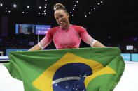 Brazil's Rebeca Andrade celebrates with the national flag after winning the gold medal on the vault during the apparatus finals at the Artistic Gymnastics World Championships in Antwerp, Belgium, Saturday, Oct. 7, 2023. (AP Photo/Geert vanden Wijngaert)