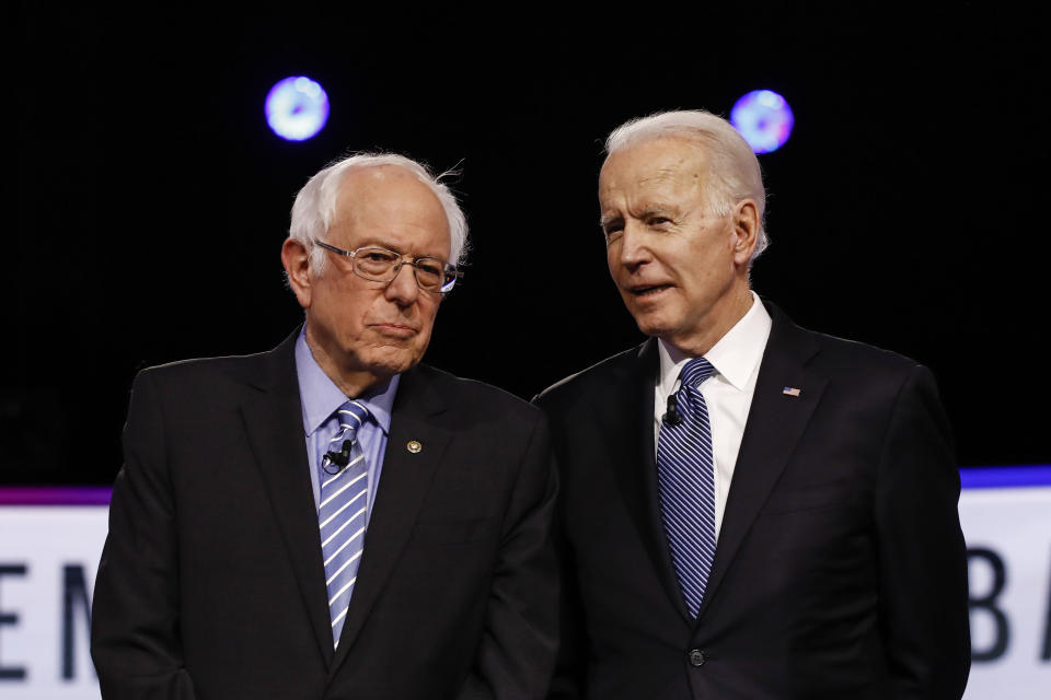FILE - In this Feb. 25, 2020 file photo, Democratic presidential candidates, Sen. Bernie Sanders, I-Vt., left, and former Vice President Joe Biden, talk before a Democratic presidential primary debate in Charleston, S.C. Political task forces Biden formed with Sanders to solidify support among the Democratic Party's progressive wing recommended Wednesday, July 8, that the former vice president embrace proposals to combat climate change and institutional racism while expanding health care coverage and rebuilding a coronavirus-ravaged economy. (AP Photo/Matt Rourke, File)
