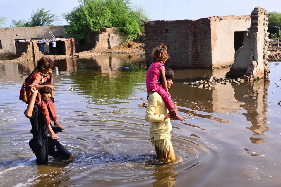 Pakistani flood victims wade through flood water after monsoon rains in Matiari, Sindh province, Pakistan, August 29, 2022. / Credit: Shakeel Ahmad/Anadolu Agency/Getty