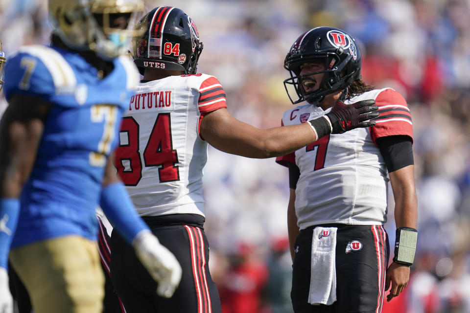 Utah quarterback Cameron Rising (7) celebrates with tight end Taniela Pututau (84) after scoring a two-point conversion during the second half of an NCAA college football game against UCLA in Pasadena, Calif., Saturday, Oct. 8, 2022. (AP Photo/Ashley Landis)