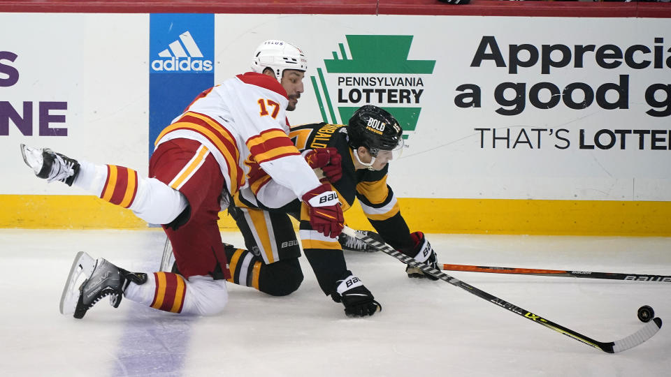 Calgary Flames' Milan Lucic (17) can Pittsburgh Penguins' Josh Archibald collide during the first period of an NHL hockey game in Pittsburgh, Wednesday, Nov. 23, 2022. (AP Photo/Gene J. Puskar)