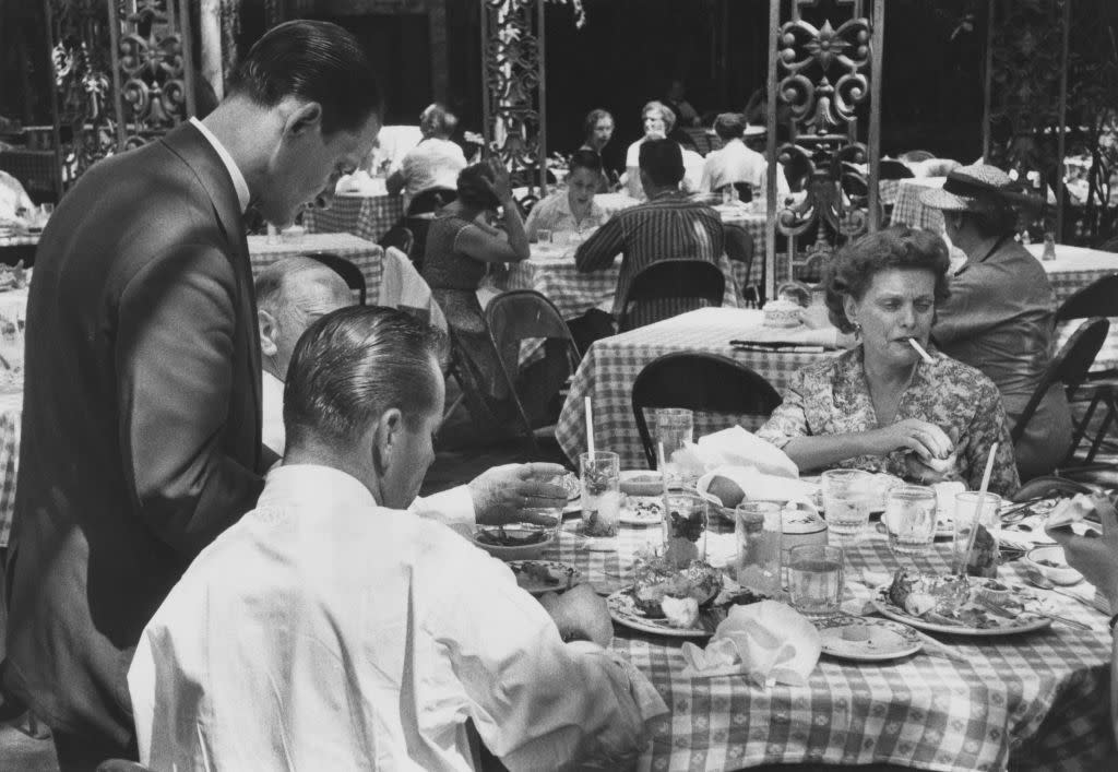 Diners in the courtyard at The Court of Two Sisters restaurant on Royal Street, in the French Quarter of New Orleans, Louisiana, USA, circa 1950