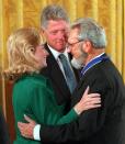 President Clinton looks on as first lady Hillary Rodham Clinton hugs former U.S. Surgeon General C. Everett Koop at the White House Friday, Sept. 29, 1995, after Koop received a Presidential Medal of Freedom. (AP Photo/Ron Edmonds)