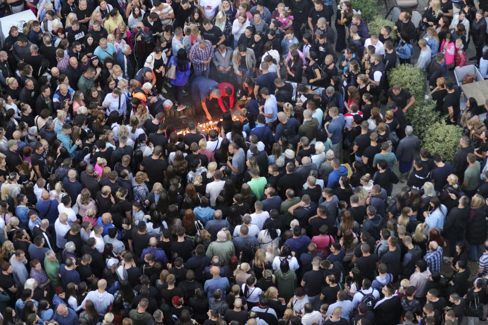 People light candles for the three killed Serbs in northern Serb-dominated part of ethnically divided town of Mitrovica, Kosovo, Tuesday, Sept.26, 2023. A Kosovo Serb party proclaimed three days of mourning starting Tuesday in Serb-dominated northern Kosovo for the three killed Serb assailants. Serbia's president demanded Tuesday to have a NATO-led peacekeeping force take over for the national law enforcement agency in northern Kosovo after a daylong shootout between armed Serbs and Kosovar police left one officer and three gunmen dead. (AP Photo/Bojan Slavkovic)