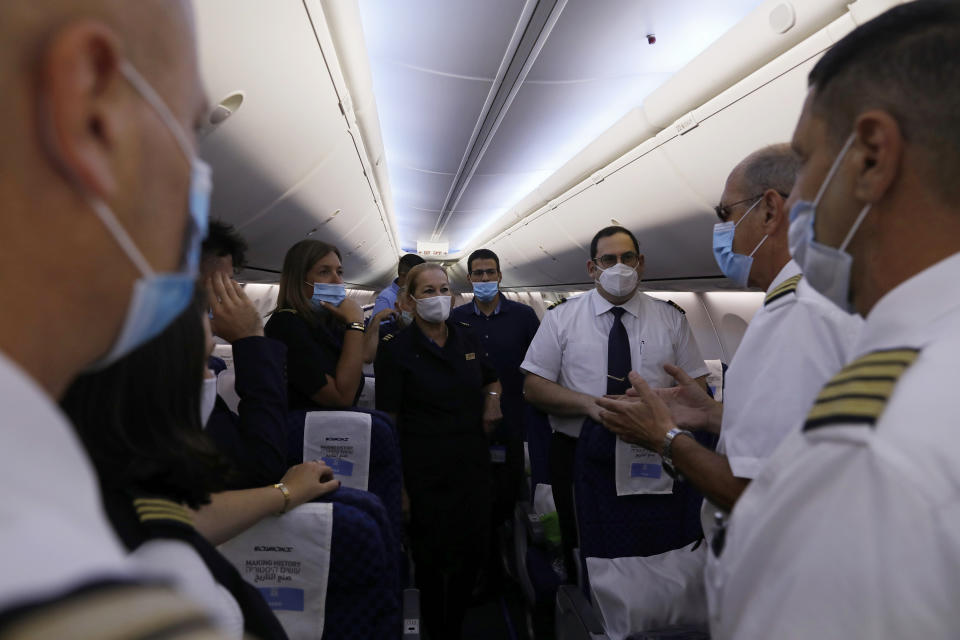 People including flight crew members are seen in the Israeli flag carrier El Al's airliner which will carry Israeli and U.S. delegations to Abu Dhabi for talks meant to put final touches on the normalization deal between the United Arab Emirates and Israel, at Ben Gurion International Airport, near Tel Aviv, Israel Monday, Aug. 31, 2020. (Nir Elias/Pool Photo via AP)