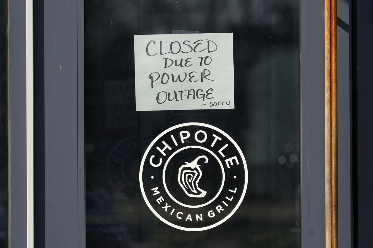A closed due to power outage sign hangs on the door at a Chipotle Mexican Grill restaurant in Detroit, Friday, Feb. 24, 2023. Michigan is shivering through extended power outages caused by one of the worst ice storms in decades. (AP Photo/Paul Sancya)