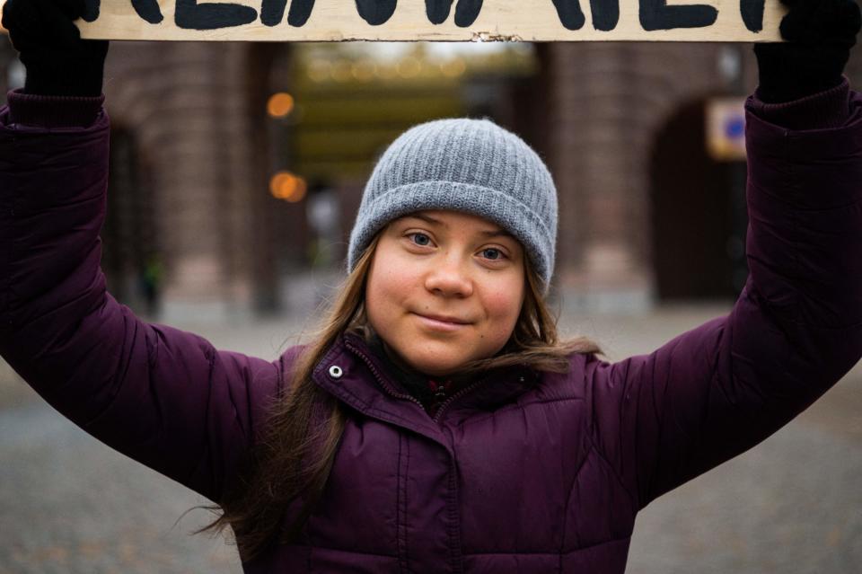 Swedish climate activist Greta Thunberg holding a sign reading 'School strike for Climate' as she protests in front of the Swedish Parliament