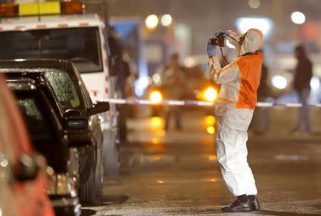 A Belgian forensic police takes pictures during police operations in Schaerbeek following Tuesday's bomb attacks in Brussels, Belgium, March 25, 2016. REUTERS/Vincent Kessler